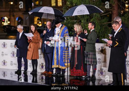 London, Großbritannien. Dezember 2024. Das jährliche Weihnachtsfest am Trafalgar Square wird von dem Bürgermeister von Westminster, dem Stadtrat Robert Rigby, begleitet von der Bürgermeisterin von Oslo, Anne Lindboe, dem Bürgermeister von London, Sadiq Khan und anderen VIPs. In einer langen Tradition ist der Baum ein Geschenk der Stadt Oslo, dieses Jahr eine 60 Jahre alte norwegische Fichte. In einer anderen offensichtlichen Tradition regnete es erneut stark für die Zeremonie. Quelle: Imageplotter/Alamy Live News Stockfoto