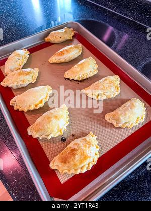 Frisch gebackene Golden Empanadas auf einem Backblech Stockfoto