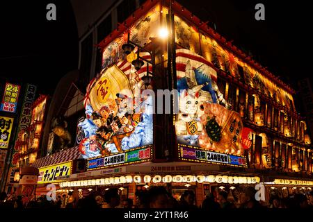 OSAKA, Japan - 26. Oktober 2024: Eine farbenfrohe japanische Straße mit lebhaften Gebäudefassaden bei Nacht. Stockfoto