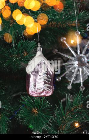 Shiny House – ein Retro-Spielzeug aus Glas, das an einem Weihnachtsbaumzweig hängt. Sowjetische Vintage-Weihnachtsbaumdekoration in modernem Design. Stockfoto