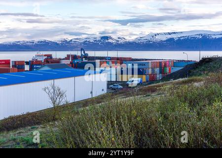 Husavik, Island, 21.05.22. Im Hafen von Husavik gelagerte Versandcontainer mit schneebedeckten Bergen im Hintergrund. Stockfoto