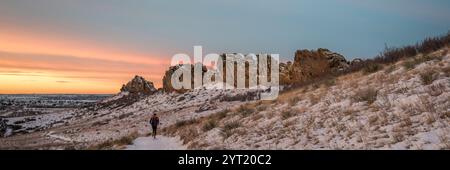 Wintersonnenaufgang über einem Pfad in den Ausläufern von Colorado mit einem Läufer in der Ferne: Devils Backbone Felsformation bei Loveland Stockfoto