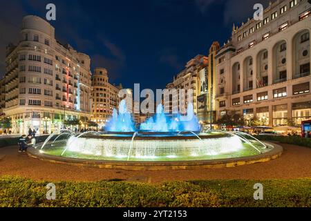 Valencia, der beleuchtete Brunnen auf der Plaza del Ayuntamiento bei Nacht Stockfoto