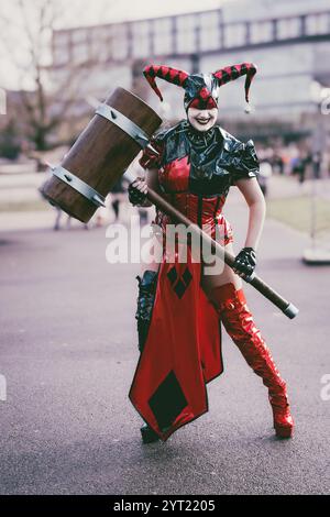 BIRMINGHAM, GROSSBRITANNIEN - 30. NOVEMBER 2024. Eine weibliche Cosplayer verkleidet als Harley Quinn aus der Batman-Franchise, lacht und hat Spaß in einem pvc-Kostüm bei A Stockfoto