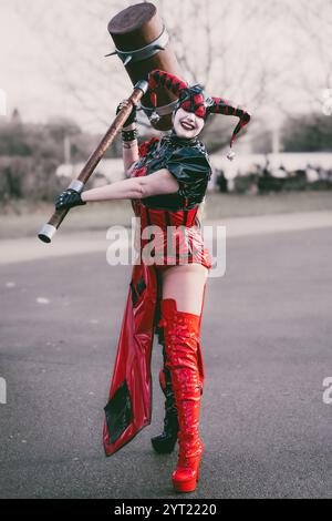 BIRMINGHAM, GROSSBRITANNIEN - 30. NOVEMBER 2024. Eine weibliche Cosplayer verkleidet als Harley Quinn aus der Batman-Franchise, lacht und hat Spaß in einem pvc-Kostüm bei A Stockfoto