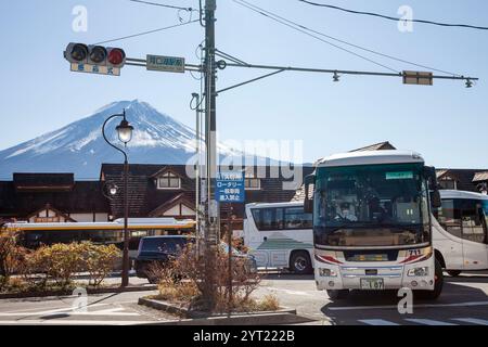 Kawaguchiko Station in der Präfektur Yamanashi, Japan mit schneebedecktem Mt. Fuji im Hintergrund und ein Bus im Vordergrund. Stockfoto