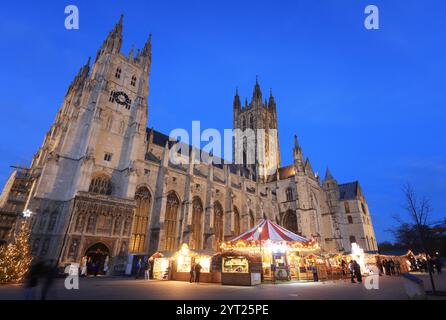 Ein Weihnachtsmarkt aus 600 Jahren ist zum ersten Mal seit 200 Jahren auf dem Gelände der Kathedrale von Canterbury mit Karussell und Chalets zurückgekehrt. Stockfoto