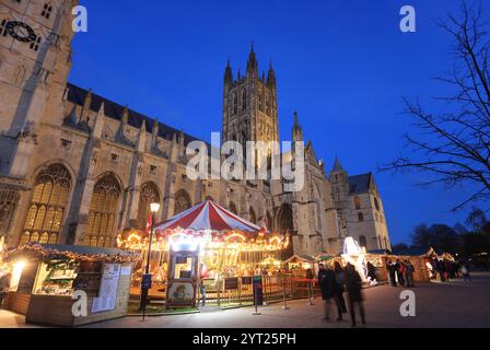 Ein Weihnachtsmarkt aus 600 Jahren ist zum ersten Mal seit 200 Jahren auf dem Gelände der Kathedrale von Canterbury mit Karussell und Chalets zurückgekehrt. Stockfoto