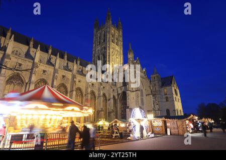 Ein Weihnachtsmarkt aus 600 Jahren ist zum ersten Mal seit 200 Jahren auf dem Gelände der Kathedrale von Canterbury mit Karussell und Chalets zurückgekehrt. Stockfoto