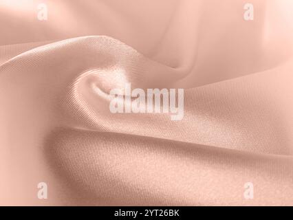 Falten von Seidenkleidung Nahaufnahme, Concept Color of Year 2025 Mokka Mousse. Glänzende Mokka Mousse Seidenhintergrund mit eleganter Textur und Kopierraum für t Stockfoto