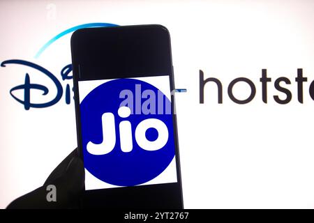 In dieser Fotoabbildung wird ein Reliance JIO Logo auf einem Smartphone mit einem Disney Hotstar Logo im Hintergrund angezeigt. Stockfoto