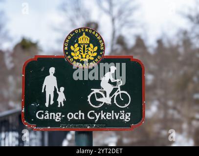 Stockholm, Schweden - 26. Februar 2023: Ein Schild in einem schneebedeckten Park hat einen dunkelgrünen Hintergrund mit einem roten Rand, auf dem weiße Symbole stehen Stockfoto