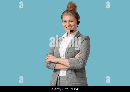 Weibliche Mitarbeiterin des technischen Supports im Headset auf blauem Hintergrund Stockfoto