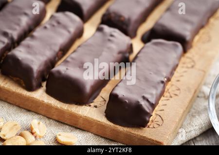 Hausgemachte, gesunde Tische aus Molkenproteinpulver und Erdnussbutter, die mit Schokolade überzogen sind Stockfoto