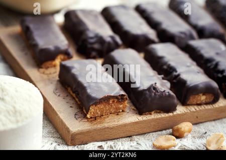 Hausgemachte, gesunde Tische aus Molkenproteinpulver und Erdnussbutter, die mit Schokolade überzogen sind Stockfoto