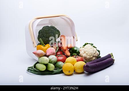 Gesundes Gemüse und frisches Obst aus dem Korb werden auf weißem Hintergrund und gemahlen fotografiert Stockfoto