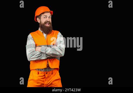 Baumeister in Helm und Weste. Hübscher Mann mit Bart und Schutzhelm und reflektierender Jacke lächelnd. Bauen, Glück, Beruf Stockfoto