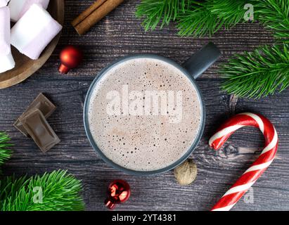 Köstliches heißes Winterkakaogetränk mit Schokoladenstückchen, Marshmallows, Fichtenzweigen und Weihnachtskugeln. Draufsicht. Stockfoto