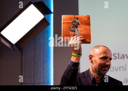 Prag, Tschechische Republik. Dezember 2024. Veröffentlichung des Buches Millionen von Momenten über die Geschichte des Foto-Newsrooms der Tschechischen Presseagentur (CTK) in einer ganztägigen Veranstaltung anlässlich des 100. Jahrestages des Starts des CTK-Fotodienstes im PressCentrum CTK, Opletalova Straße, in Prag, Tschechische Republik, 5. Dezember, 2024. auf dem Foto präsentiert der Leiter der CTK Photobank Petr Mlch das Buch. Quelle: Ondrej Deml/CTK Photo/Alamy Live News Stockfoto