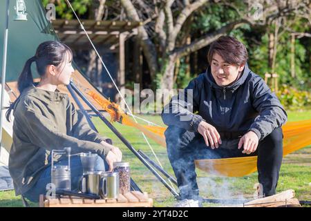 Mann und Frau unterhalten sich auf einem Campingplatz Stockfoto