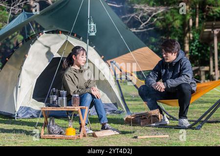 Mann und Frau unterhalten sich auf einem Campingplatz Stockfoto
