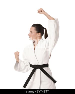 Junge Frau im Kimono, die Karate auf weißem Hintergrund übt Stockfoto