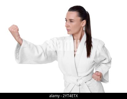Junge Frau im Kimono, die Karate auf weißem Hintergrund übt Stockfoto