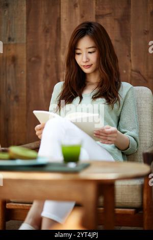 Frau liest im Café Stockfoto