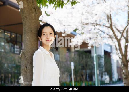 Frau, die sich vor Kirschblüten entspannt Stockfoto