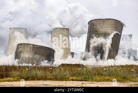 Boxberg, Deutschland. Dezember 2024. Die seit 1996 stillgelegten Kühltürme des Kraftwerks Boxberg II stürzen nach der Explosion zusammen. Die Kühltürme standen jahrzehntelang für den Betrieb des Kraftwerks und haben die Region optisch geprägt. Das Kraftwerk Boxberg wird von der Lausitz Energie Kraftwerke AG (LEAG) betrieben. Robert Michael/dpa/Alamy Live News Stockfoto