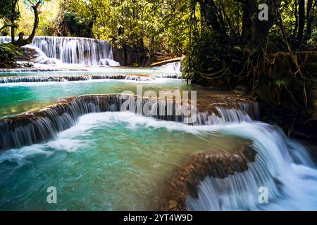 Türkisfarbenes Wasser des Kuang Si Wasserfalls, Luang Prabang. Laos. Glatte Felsen mit kaskadierendem Wasser bilden eine Reihe von schönen kurzen Wasserfällen in der Dichte Stockfoto