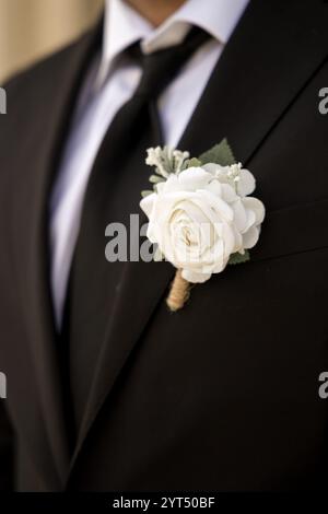 Bräutigam trägt Boutonniere mit weißer Rose Stockfoto