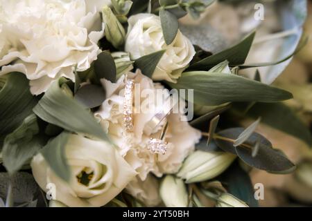 Elegante Eheringe auf weißen Blumen Stockfoto