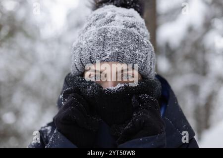 Nahaufnahme einer jungen Frau mit schneebedecktem Schal und Hut Stockfoto