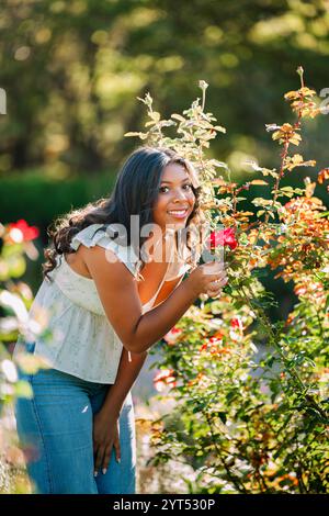 Model posiert in einem Garten mit einer Rose Stockfoto