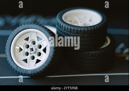 Drei weiße und schwarze Lego-Räder sind übereinander gestapelt. Die Räder bestehen aus Kunststoff und haben einen schwarzen Gummireifen. Polen, Warschau 06.12.2024 Stockfoto