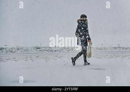 Brünn, Tschechische Republik. Dezember 2024. Am 6. Dezember 2024 spaziert eine Fußgängerin durch intensiven Schneefall in Brünn. Quelle: Patrik Uhlir/CTK Photo/Alamy Live News Stockfoto