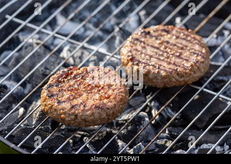 Gegrillte Burger-Fleischpasteten auf brennendem Holzkohlegrill, selektiver Fokus Stockfoto