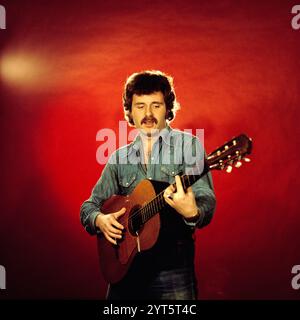 Der polnische Popsänger, Gitarrist und Songwriter Krzysztof Krawczyk im Porträt mit Gitarre beim Fotoshooting im Fotostudio von Tassilo Leher in Ost-Berlin für das Album-Cover seines Alben 'Rysunek na Szkle', DDR 1976. Stockfoto