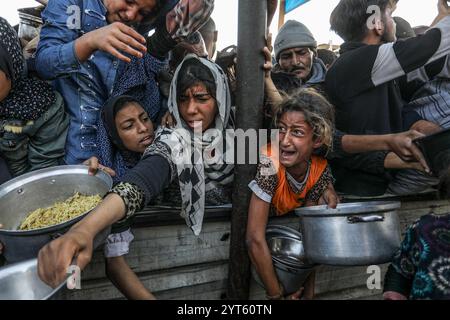 Khan Younis, Palästinensische Gebiete. Dezember 2024. Vertriebene Palästinenser überschwemmen sich, um Mahlzeiten aus der Rafah Charitable Kitchen (Tekia) in Khan Younis zu erhalten. Die Vereinten Nationen und internationale Organisationen warnen vor einer Hungersnot im Gazastreifen und fordern alle Konfliktparteien, palästinensischen Fraktionen und die israelische Regierung nachdrücklich auf, die Einfahrt von Hilfsfahrzeugen in den Gazastreifen zu gestatten und ihre Missionen zu erleichtern, um eine humanitäre Katastrophe im Gazastreifen aufgrund des anhaltenden Konflikts zwischen Israel und der Hamas zu vermeiden. Abed Rahim Khatib/dpa/Alamy Live News Stockfoto