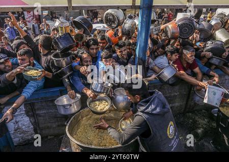 Khan Younis, Palästinensische Gebiete. Dezember 2024. Vertriebene Palästinenser überschwemmen sich, um Mahlzeiten aus der Rafah Charitable Kitchen (Tekia) in Khan Younis zu erhalten. Die Vereinten Nationen und internationale Organisationen warnen vor einer Hungersnot im Gazastreifen und fordern alle Konfliktparteien, palästinensischen Fraktionen und die israelische Regierung nachdrücklich auf, die Einfahrt von Hilfsfahrzeugen in den Gazastreifen zu gestatten und ihre Missionen zu erleichtern, um eine humanitäre Katastrophe im Gazastreifen aufgrund des anhaltenden Konflikts zwischen Israel und der Hamas zu vermeiden. Abed Rahim Khatib/dpa/Alamy Live News Stockfoto