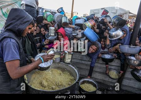 Khan Younis, Palästinensische Gebiete. Dezember 2024. Vertriebene Palästinenser überschwemmen sich, um Mahlzeiten aus der Rafah Charitable Kitchen (Tekia) in Khan Younis zu erhalten. Die Vereinten Nationen und internationale Organisationen warnen vor einer Hungersnot im Gazastreifen und fordern alle Konfliktparteien, palästinensischen Fraktionen und die israelische Regierung nachdrücklich auf, die Einfahrt von Hilfsfahrzeugen in den Gazastreifen zu gestatten und ihre Missionen zu erleichtern, um eine humanitäre Katastrophe im Gazastreifen aufgrund des anhaltenden Konflikts zwischen Israel und der Hamas zu vermeiden. Abed Rahim Khatib/dpa/Alamy Live News Stockfoto