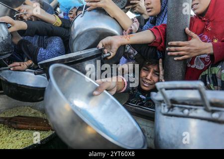 Khan Younis, Palästinensische Gebiete. Dezember 2024. Vertriebene Palästinenser überschwemmen sich, um Mahlzeiten aus der Rafah Charitable Kitchen (Tekia) in Khan Younis zu erhalten. Die Vereinten Nationen und internationale Organisationen warnen vor einer Hungersnot im Gazastreifen und fordern alle Konfliktparteien, palästinensischen Fraktionen und die israelische Regierung nachdrücklich auf, die Einfahrt von Hilfsfahrzeugen in den Gazastreifen zu gestatten und ihre Missionen zu erleichtern, um eine humanitäre Katastrophe im Gazastreifen aufgrund des anhaltenden Konflikts zwischen Israel und der Hamas zu vermeiden. Abed Rahim Khatib/dpa/Alamy Live News Stockfoto