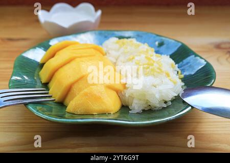 Teller mit berühmtem thailändischem Dessert aus frischer reifer Mango mit Kleberreis und Kokosmilch Stockfoto