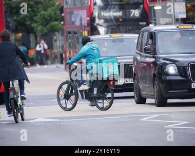 Deliveroo Lieferfahrer auf Port E-Bike im Verkehr in der Nähe der Liverpool Street Station London Stockfoto