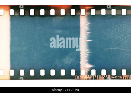 Staubige und schmutzige 35-mm-Filmtextur oder -Oberfläche. Perforierter, zerkratzter Kamerafilm isoliert auf weißem Hintergrund. Stockfoto