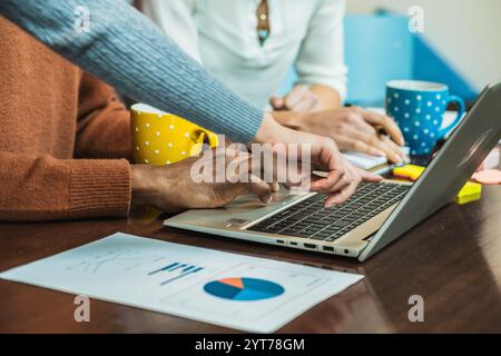 Geschäftsteam arbeitet an einem Laptop zusammen und analysiert Finanzdaten in einem Meeting Stockfoto