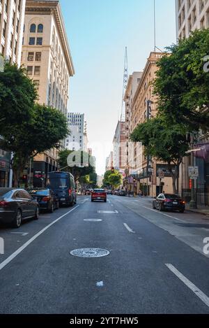 Eine geschäftige Straßenszene im Zentrum von Los Angeles bietet das historische Orpheum Theatre-Schild, hohe Gebäude, alte Bäume und einen klaren blauen Himmel auf einer sonnigen Sonne Stockfoto