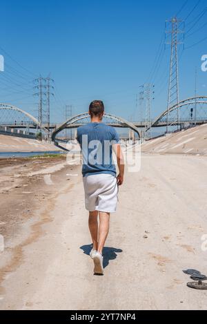 Person, die am Los Angeles River mit Sixth Street Viaduct vorbeiläuft Stockfoto