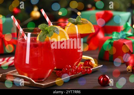 Weihnachtscocktail in Gläsern mit Zitrone und Johannisbeeren auf Holztisch, Nahaufnahme Stockfoto